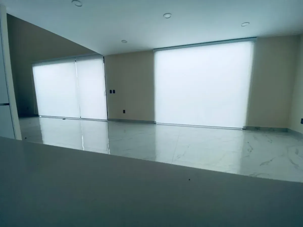 Persianas enrollables traslúcidas blancas en una estancia amplia con piso claro